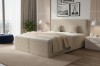 Beiges Boxspringbett mit geripptem Bezug und passendem Kopfteil in modernem Schlafzimmer.