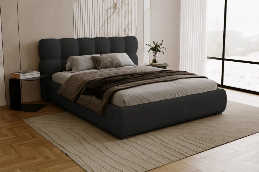 Stylish upholstered bed in dark grey in a modernly furnished bedroom with window front.