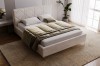 Gemütliches beige Polsterbett in modernem Schlafzimmer aus seitlicher Perspektive.