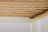 Sturdy wooden slatted frame for a children's bed with flexible slats and black retaining strap.