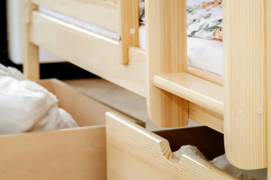 Nahaufnahme einer ausziehbaren Bettschublade aus Massivholz unter einem Kinderbett.