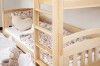 Bunk bed made of pine wood with ladder and floral bedding in the children's room.