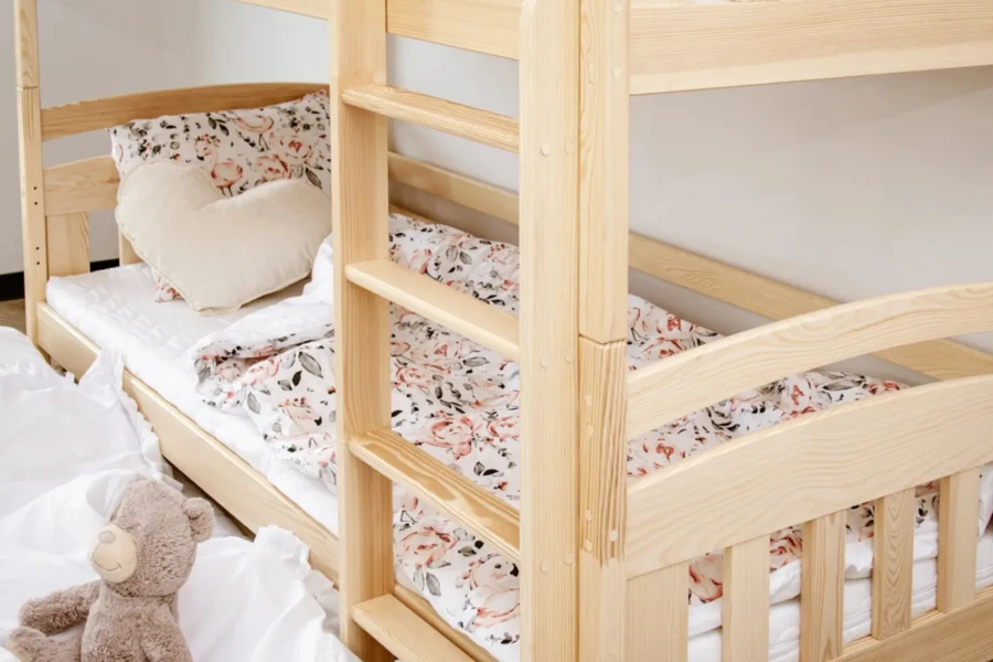 Bunk bed made of pine wood with ladder and floral bedding in the children's room.