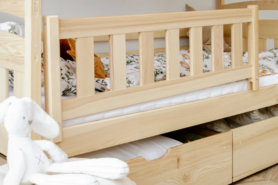 Massivholz-Kinderbett mit Rausfallschutz und geräumigen Bettschubladen für Stauraum.