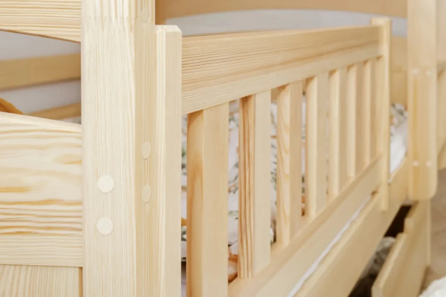 Detailansicht der hochwertigen Verarbeitung und des Rausfallschutzes am Holzbett.
