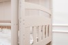 Stable construction of a bunk bed in beige with rounded wooden elements.