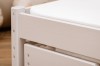 Detailansicht eines massiven Holzbetts in Beige mit sichtbarer Maserung.