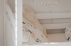 Bovenste stapelbed met witte houten spijlen en decoratieve kussens