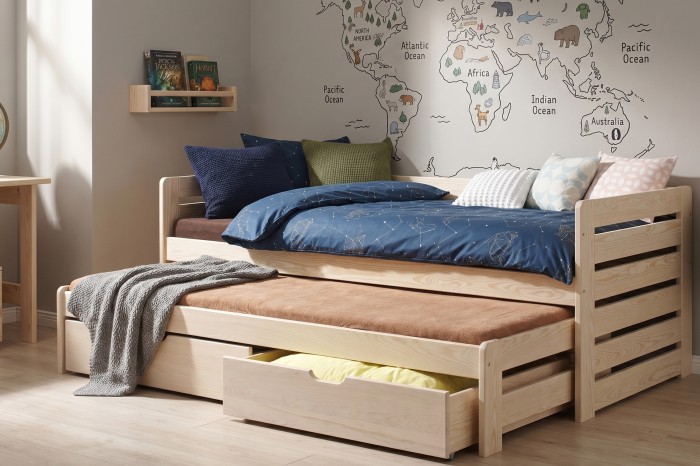 Helles Holz-Kinderbett mit Ausziehfunktion und Bettkasten in wohnlicher Umgebung.