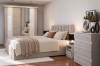 Elegantes Schlafzimmer mit Heaven Möbeln: Fokus auf Bett, Kommode und Schwebetürenschrank mit Spiegel.