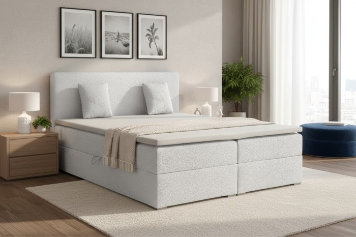 Modernes hellgraues Boxspringbett im stilvoll eingerichteten Schlafzimmer