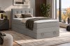 Modernes hellgraues Boxspringbett im Schlafzimmer mit dunklem Nachttisch.