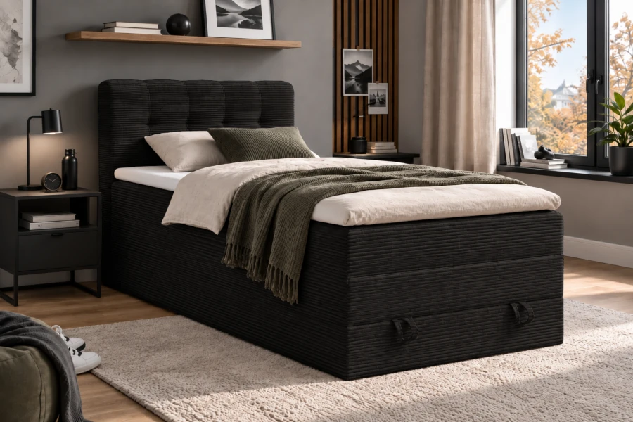 Dunkelgraues Boxspringbett aus Cord mit praktischen Stauraumschlaufen.