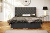 Modernes graues Boxspringbett in einem stilvoll eingerichteten Schlafzimmer.